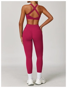 Dettaglio del set da yoga rosa con reggiseno sportivo incrociato e leggings a vita alta
