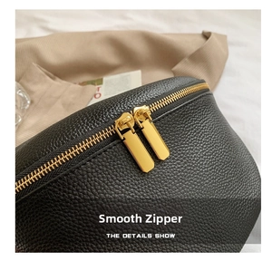 Macro view of smooth golden dual metal zippers on black lychee grain leather bag