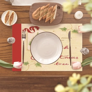 Christmas tree snowman placemat with beige woven texture and red border on dark wooden table