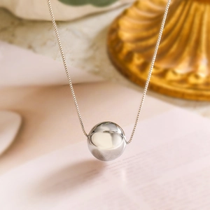 Minimalist silver spherical pendant necklace on fine chain with a smooth polished finish