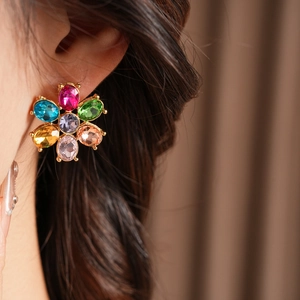 Close-up of vintage flower earrings with colorful crystal petals on gold-tone metal base