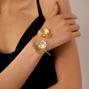 Détail d'un bracelet manchette fleur dorée avec cristaux sur un mannequin femme
