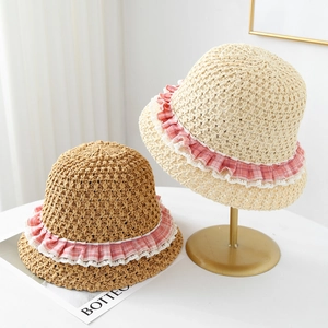 Detailed view of hand-woven straw hat with lace edges and plaid ruffle trim decor