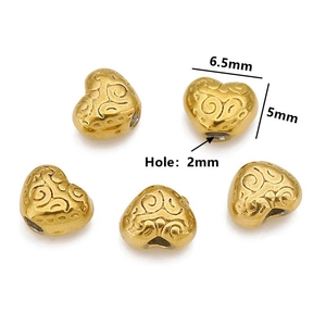 Macro view of gold stainless steel heart bead with dimensions 6.5mm by 5mm and 2mm hole