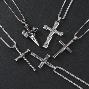 Set of five stainless steel cross pendants with twisted chains on a black textured surface