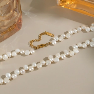 Detailed view of natural baroque freshwater pearls with a gold-tone clasp and chain