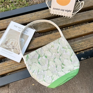 Detail of floral tulip canvas bucket bag on a park bench with magazines for styling