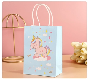 Close-up of a blue paper gift bag featuring a cute unicorn and white rope handles