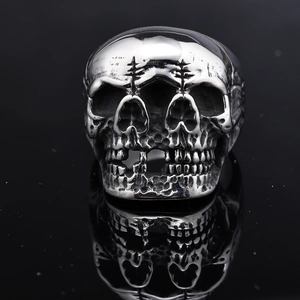 Detailed close-up of a punk style double skull ring with oxidized silver finish and cross marks