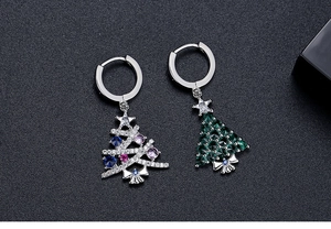 Detailed close-up of asymmetric Christmas tree earrings with colorful zircon stones