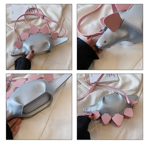 Detail view showing inner capacity and pink dinosaur spikes on silver crossbody bag