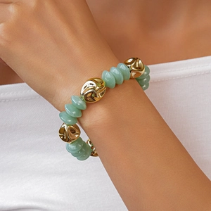 Close-up of vintage translucent green beads and textured gold metal beads on the wrist