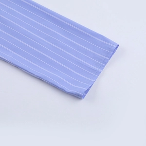Dettaglio del polsino della camicia a righe blu con cuciture pulite e tessuto cotone