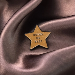 Vintage gold star brooch with 'Doing My Best' lettering on elegant brown silk background