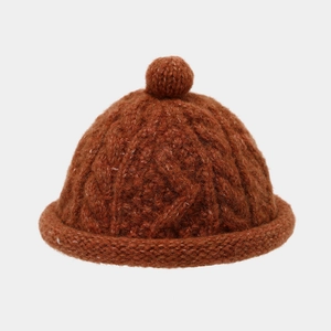 Retro cable knit beanie in rust red with fluffy pompom and rolled edge for winter warmth