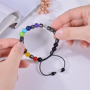 Detail of 8mm seven chakra natural stone beads on an adjustable black braided rope bracelet