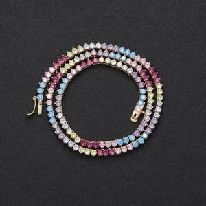 Detail der 3mm Regenbogen-Tenniskette mit bunten Steinen und Goldbasis auf schwarzem Grund