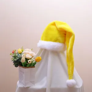 Detail of a bright yellow plush long-tail Christmas hat with soft white pompom and fur trim