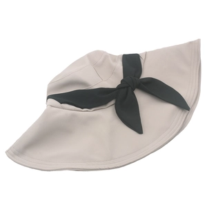 Dettaglio cappello parasole a tesa larga con grande fiocco nero in tessuto beige