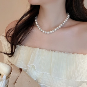 Elegant pearl necklace on a model's neck, showcasing a minimalist French style design