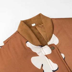 Detail von Strickbündchen und Blumenmuster auf brauner Bomberjacke mit Metallknopf-Verschluss