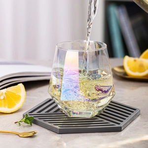 Iridescent hexagonal glass cup being filled with water in a refreshing lifestyle setting