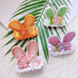 Detail view of handmade crochet rabbit ear hair clips with pearls and flowers