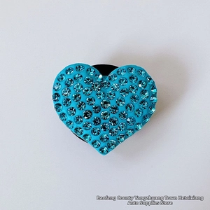 Close-up of heart-shaped air vent clip with sparkling blue rhinestones for car interior