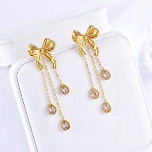 Golden bow tassel earrings with sparkling teardrop zircons in a premium jewelry box