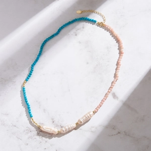 Detail of bohemian necklace with blue and pink beads and three baroque pearls