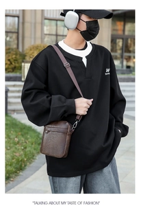 Close-up of brown PU leather crossbody bag paired with a black V-neck hoodie