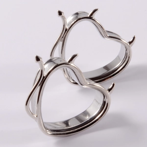 Detail of silver heart-shaped ear gauges with devil horn spikes made of stainless steel