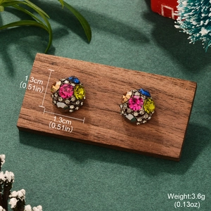 Détail macro de boucles d'oreilles boules en strass colorés sur présentoir en bois sombre