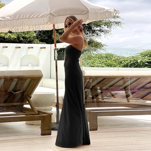 Détail de robe longue en maille noire à fines bretelles et tissu texturé pour les vacances
