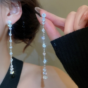 Close-up of long silver tassel earrings with shimmering gradient cubic zirconia stones