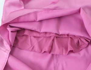Vue macro de la doublure intérieure et des coutures à volants d'une robe en satin rose