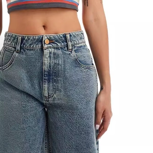 Détail du short en jean taille haute avec bouton métal et délavage flocon