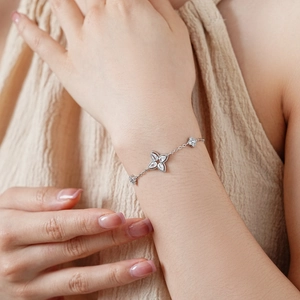 Detailed close-up of a silver flower bracelet with sparkling zircon stones on a wrist