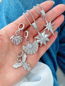 Detail shot of silver star and heart pendant necklaces with cubic zirconia on denim