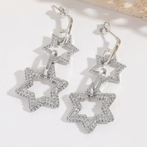 Detail of silver double star drop earrings with full crystal pavé in a geometric fringe style