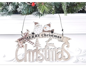 Detail eines hölzernen Merry Christmas Türschilds mit Schneeflocken und Karoschleife