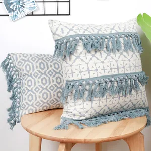 Blue geometric print cushion covers with decorative tassels on a wooden stool