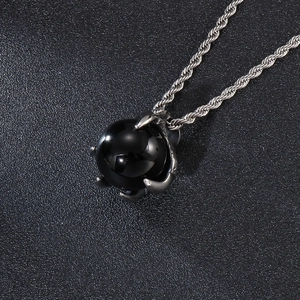 Detailed close-up of a silver dragon claw pendant holding a large black orb on a rope chain