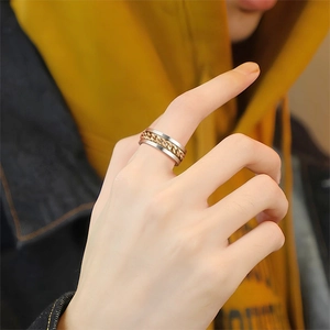 Close-up of a two-tone spinner chain ring in gold and silver on a finger