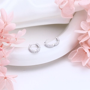 Close-up of S925 sterling silver hoop earrings with zircon and dried flowers