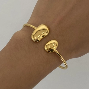 Détail d'un bracelet jonc en acier inoxydable plaqué or 18 carats porté au poignet