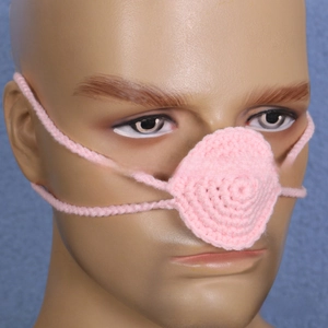Close-up of pink handmade crochet nose warmer on a display model for party props