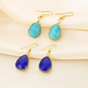 Vue détaillée des boucles d'oreilles en verre à facettes avec bordures dorées décorées