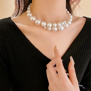 Detail of double-layer faux pearl necklace with small silver beads on a female model