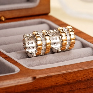 Elegant two-tone twisted hoop earrings with sparkling cubic zirconia on velvet lining